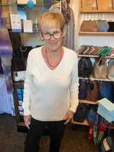 Load image into Gallery viewer, Woman standing in a store with shelves displaying bags and accessories