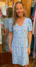 Load image into Gallery viewer, Woman wearing a blue patterned dress in a store setting